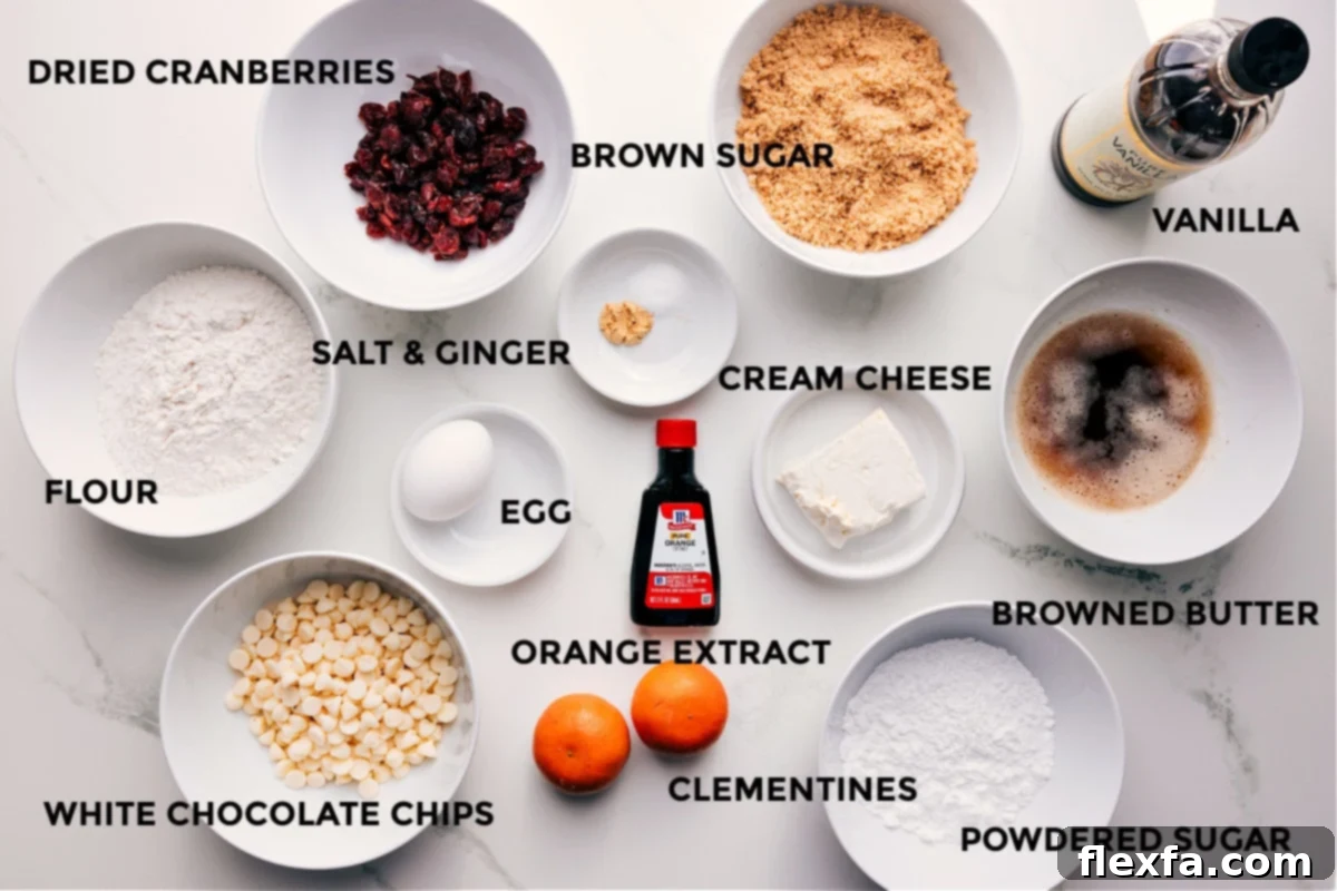 All the prepped ingredients for Cranberry Bliss Bars laid out: flour, dried cranberries, white chocolate chips, brown sugar, salt, ginger, egg, orange extract, clementines, cream cheese, powdered sugar, browned butter, and vanilla extract.