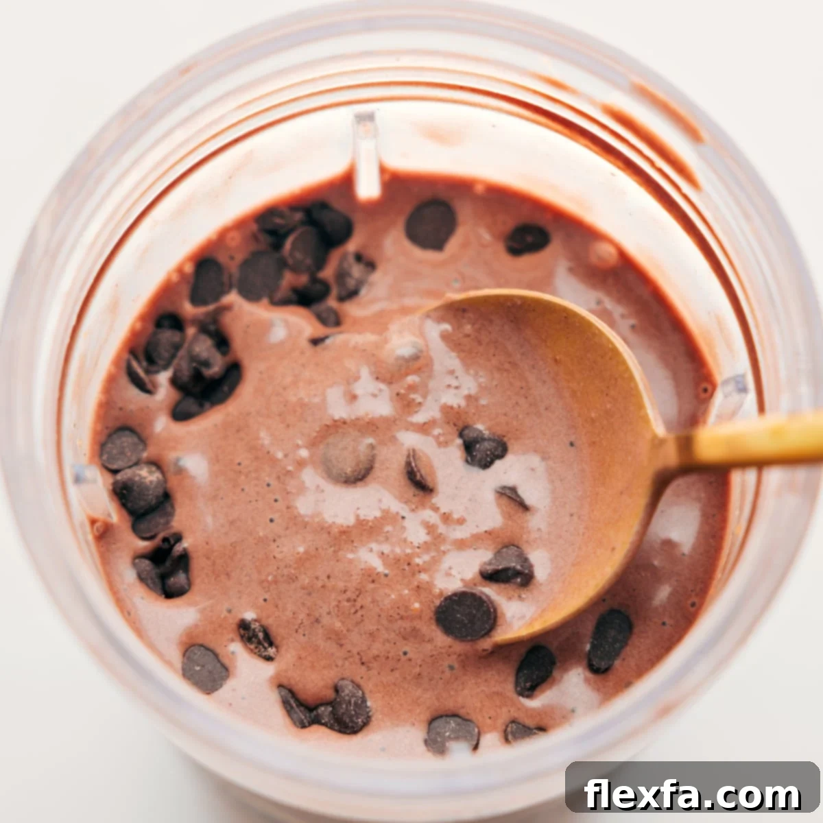 Spoonful of the delicious and creamy chocolate protein shake with chocolate chips on top for an extra delicious treat.