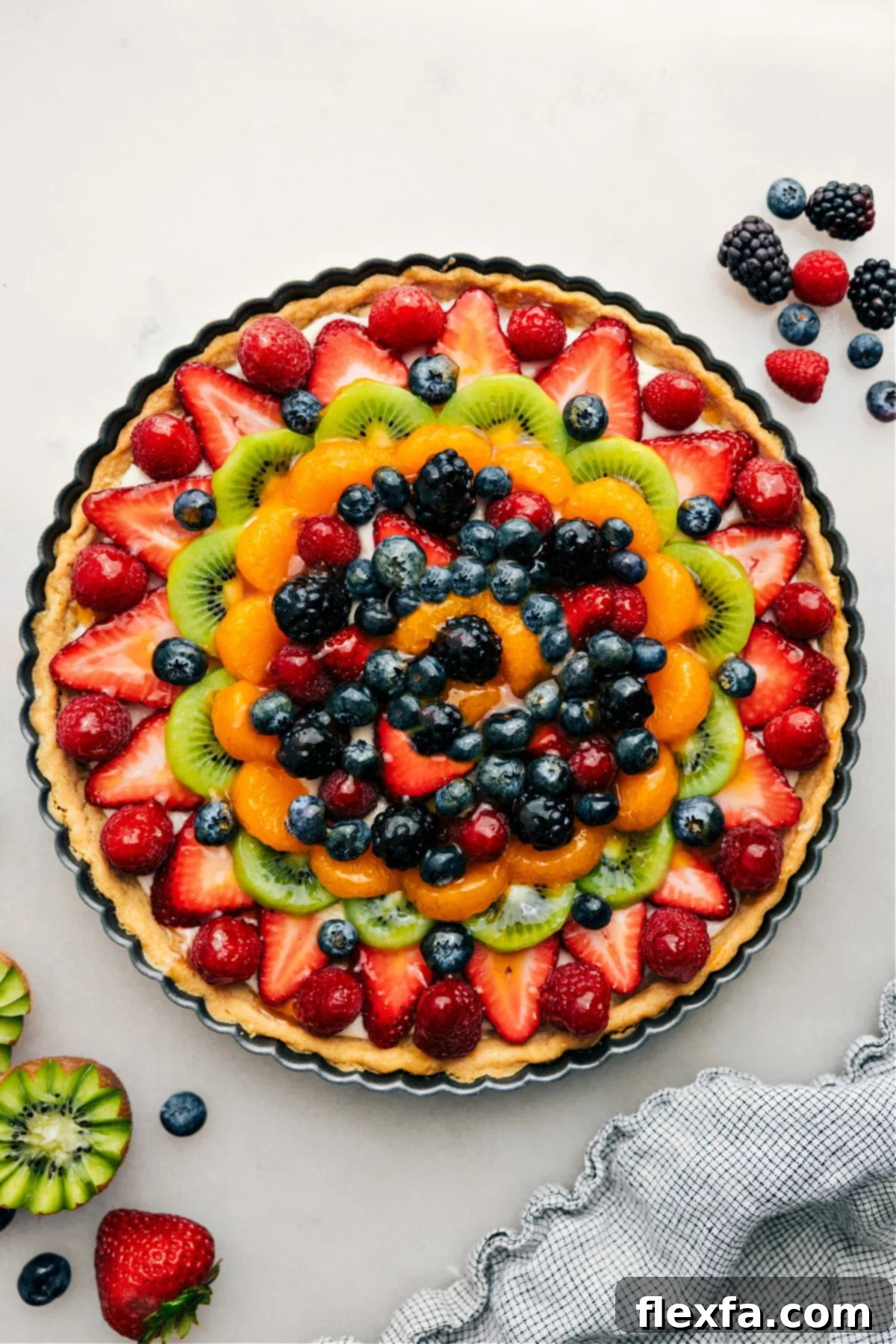A beautifully sliced fruit pizza with a sweet glaze, ready to be enjoyed as a refreshing summer dessert.