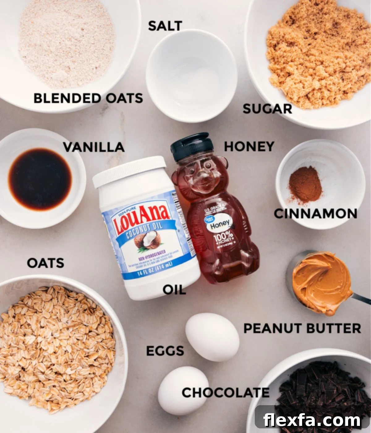 Wholesome Ingredients For Soft-Baked Oatmeal Breakfast Bars All the wholesome ingredients prepped for easy assembly of oatmeal breakfast bars, including sugar, old-fashioned oats, honey, cinnamon, eggs, creamy peanut butter, melted coconut oil, vanilla extract, and dark chocolate chips.