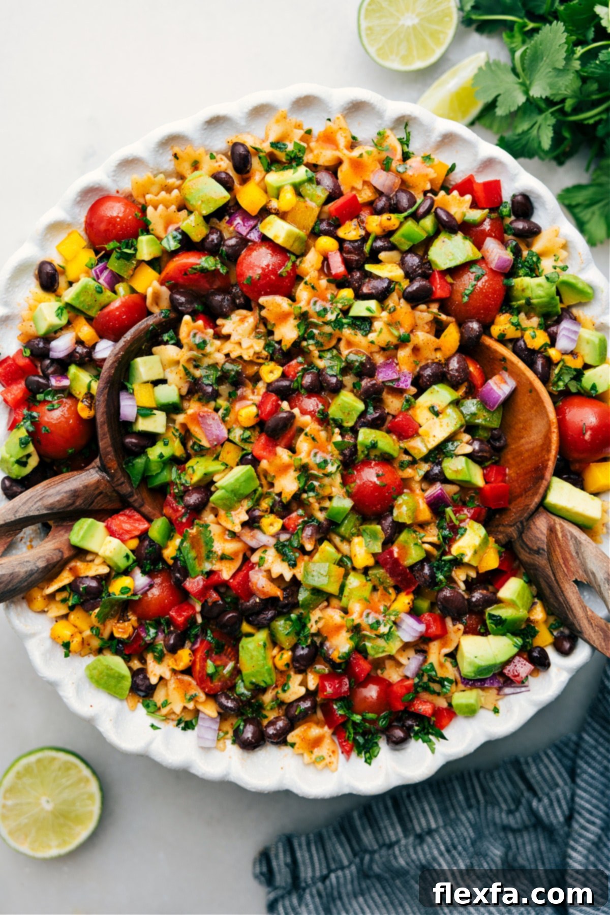 The Best Mexican Pasta Salad Recipe: Fresh & Flavorful A large, beautifully presented bowl of vibrant Mexican Pasta Salad, fully dressed and ready to serve and enjoy. It features mini bowtie pasta, corn, black beans, red bell peppers, cherry tomatoes, and fresh cilantro, all glistening with the chili-lime dressing.