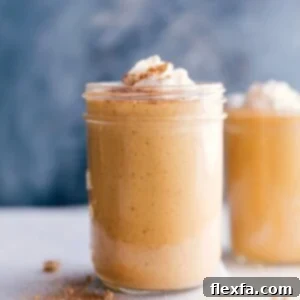 A cup filled with a creamy pumpkin protein shake, topped with a swirl of whipped cream.