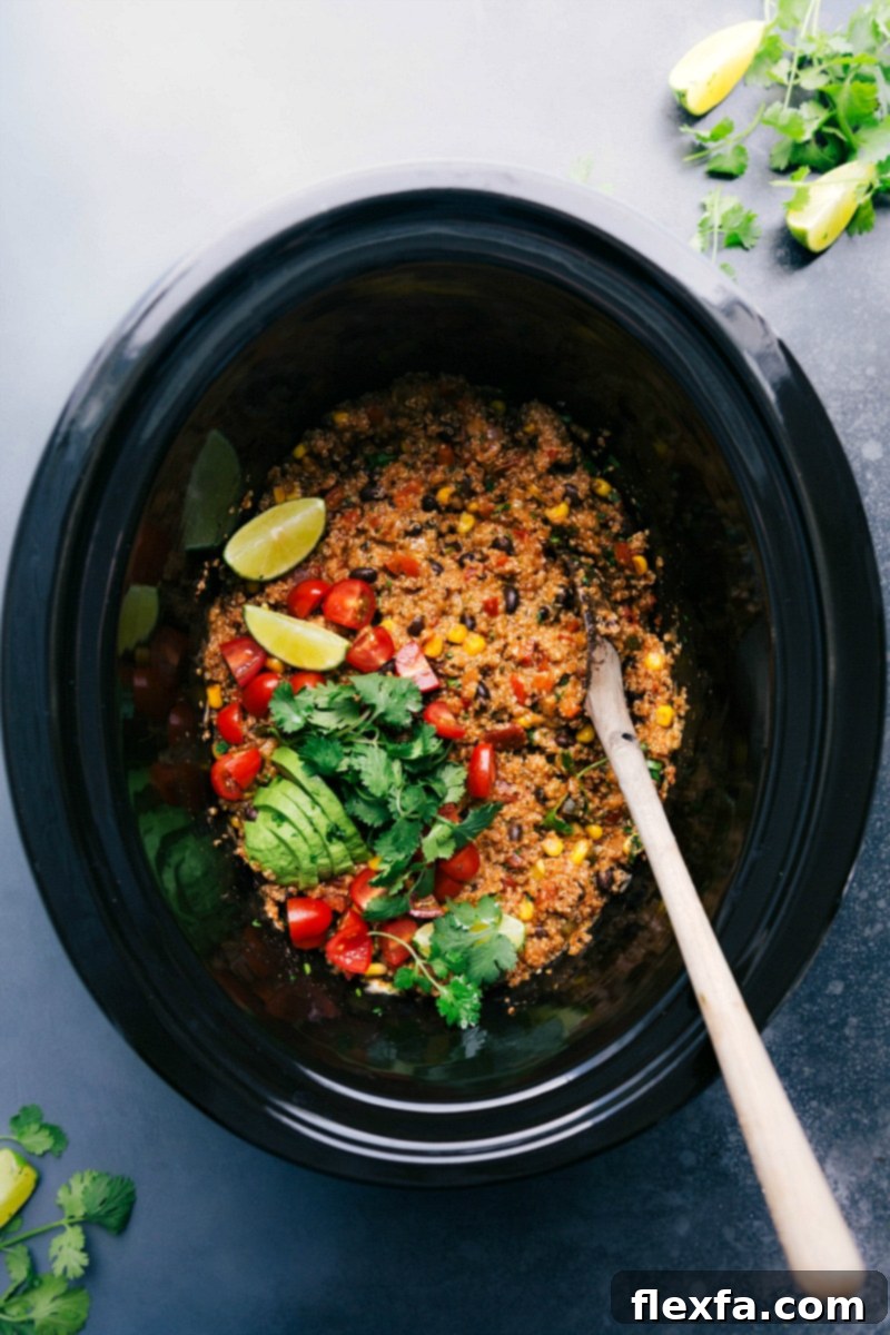A serving of Tex-Mex quinoa in the crockpot, topped with fresh cilantro and lime, ready to be dished out with a spoon.