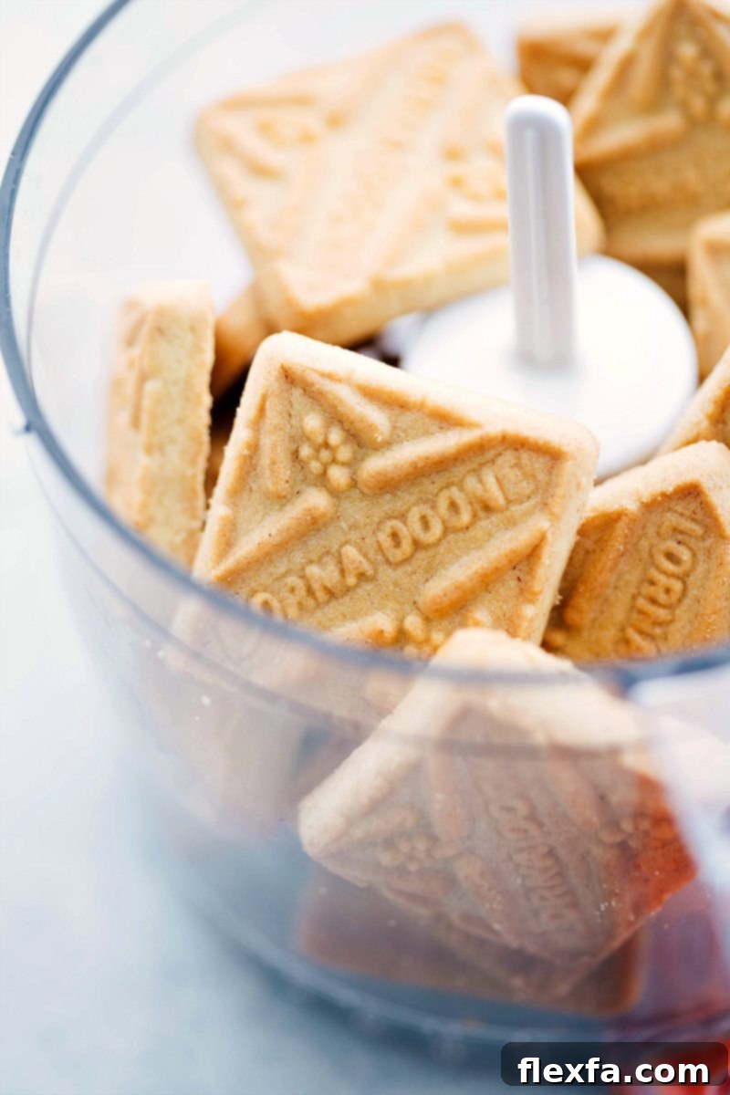 Shortbread cookies being processed in a food processor to create the crust for Twix Cheesecake Bars