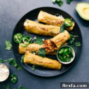 Finished crunchy pork taquitos on a plate, accompanied by sliced jalapeños, cilantro, and avocado on the side.