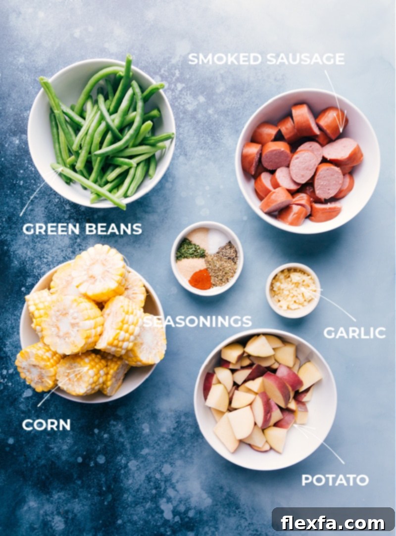 A vibrant assortment of fresh ingredients laid out on a cutting board, including smoked sausage, red potatoes, fresh green beans, corn on the cob, whole garlic cloves, and a mix of seasonings, showcasing everything needed for the easy Garlic Butter Sausage & Veggies foil pack recipe.