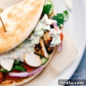 A complete chicken gyro, overflowing with chicken, vegetables, and sauce, wrapped in a soft pita, ready to be enjoyed as part of a chicken gyro recipe.
