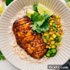 A vibrant plate of grilled taco chicken topped with fresh avocado corn salsa, ready to be served.
