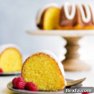 Zesty Lemon Bundt Delight 5 A beautifully presented Lemon Bundt Cake with lemon buttercream frosting, ready to be served. This image highlights the cake's vibrant color and delicate texture.