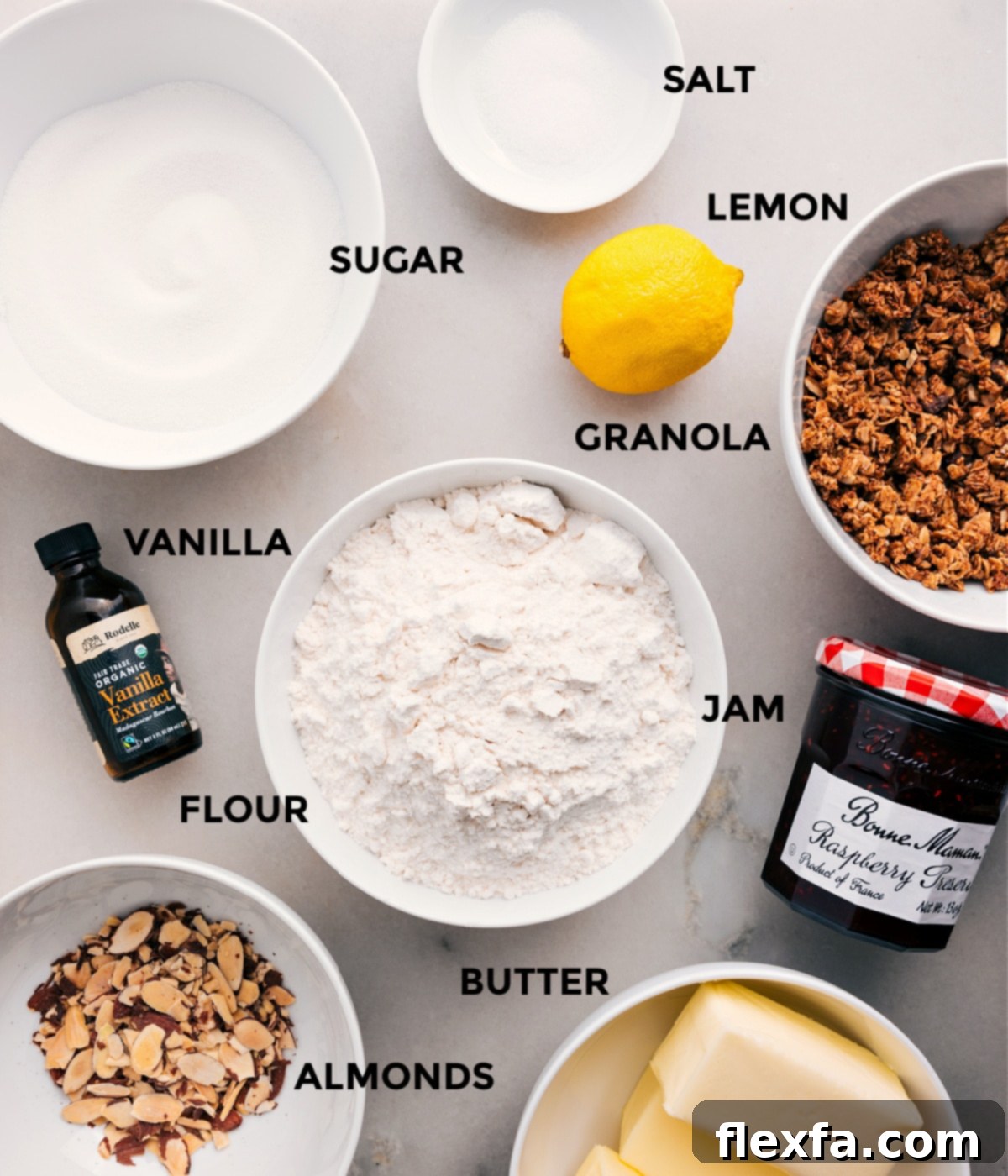 All the essential ingredients neatly prepped for making Raspberry Bars: fresh lemon, crunchy granola, sweet raspberry jam, flour, vanilla extract, sugar, salt, cold butter, and sliced almonds.