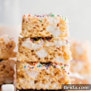 Rice Krispie Treats squares stacked on top of each other showing the gooey and delicious texture.