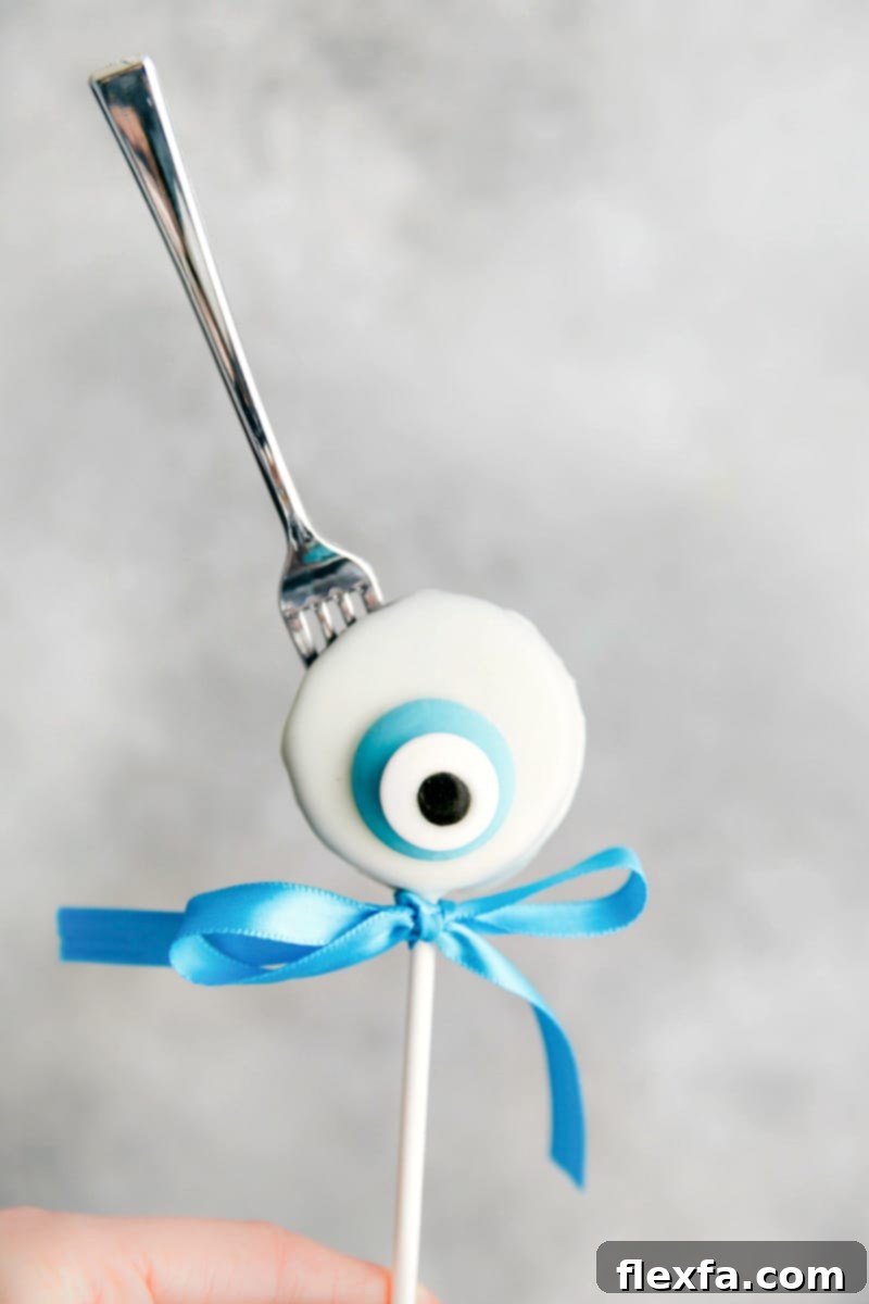 Spooktacular Oreo Pop Treats 6 A chillingly delightful Creepy Eyeball Oreo Pop, featuring a vibrant candy melt iris and a candy eye, perfect for a spooky Halloween spread.