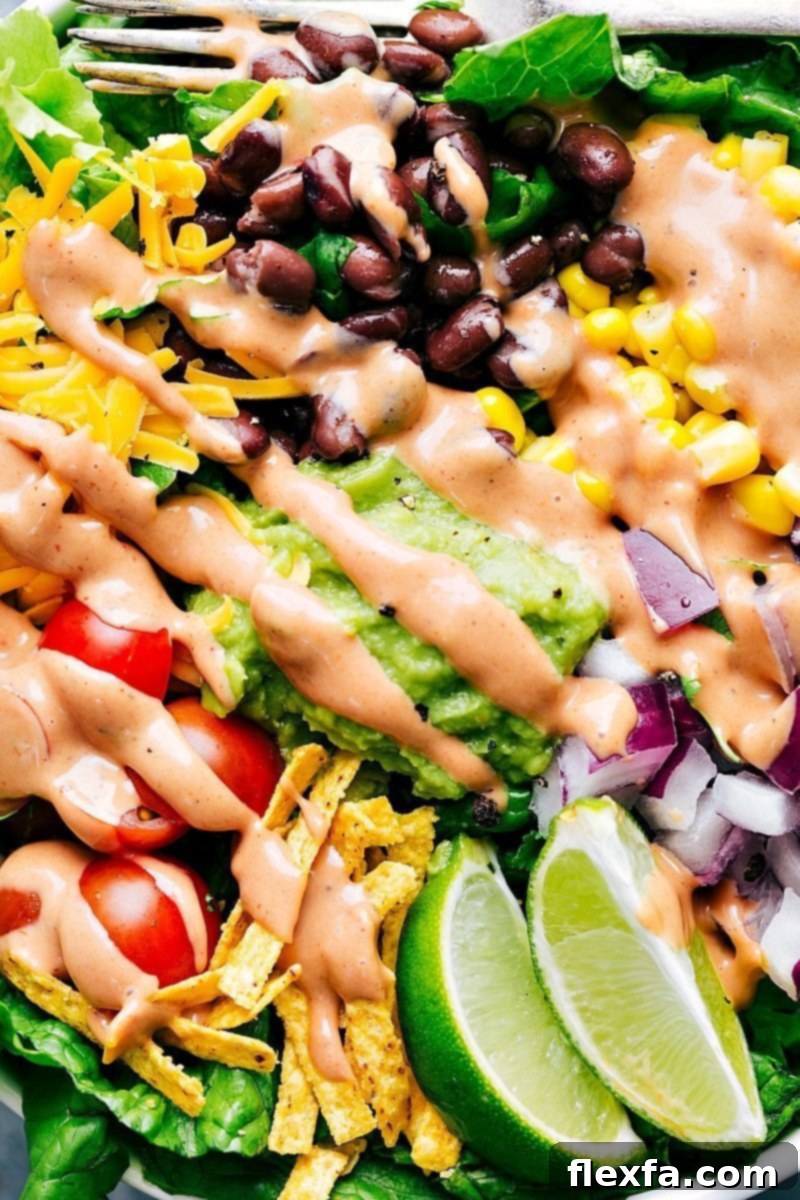 A vibrant BBQ Chicken Salad featuring crisp romaine, colorful vegetables, tender shredded BBQ chicken, and a creamy, zesty dressing – one of three versatile meals created from a single rotisserie chicken.