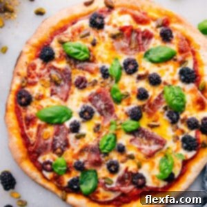 A top-down view of the baked Blackberry Basil Pizza, showing its crispy crust, melted cheese, and fresh toppings.