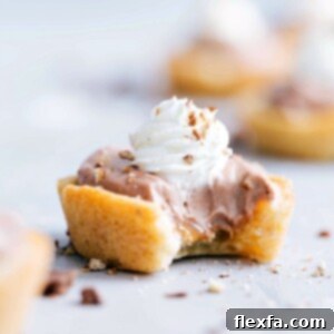 A completed Sugar Cookie Turtle Pudding Bite, showing its layers of cookie, caramel, chocolate pudding, and whipped cream with pecans, ready to be eaten.
