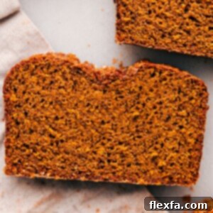 A close-up of a single slice of the tender pumpkin bread, highlighting its moist, fluffy interior and delicious texture.