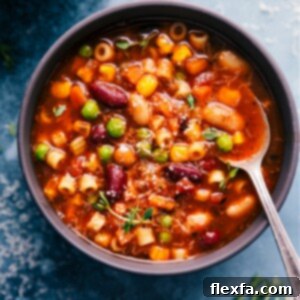 A close-up of a delicious bowl of homemade Olive Garden Minestrone Soup, garnished and ready to serve.