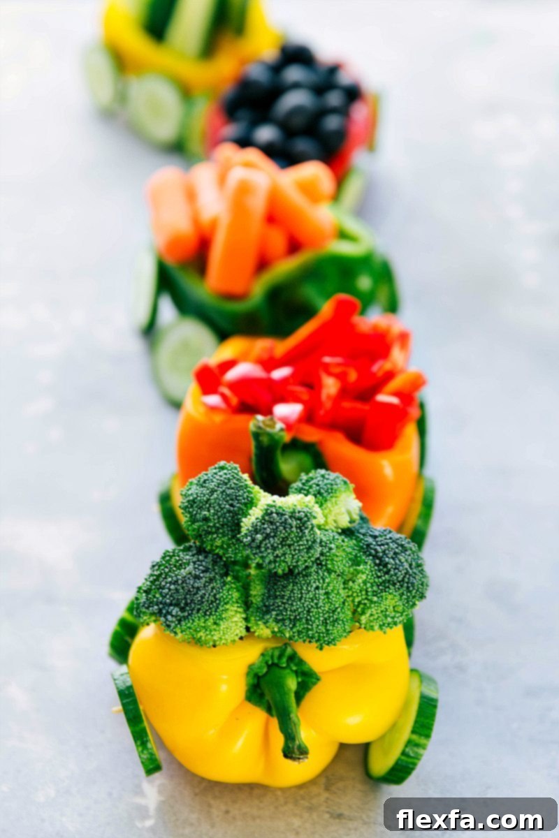 An imaginative arrangement of fresh vegetables configured to look like a cheerful train, perfect for a Christmas party, a child's birthday celebration, or any festive occasion. A small bowl of delicious dip is positioned conveniently nearby for easy snacking.