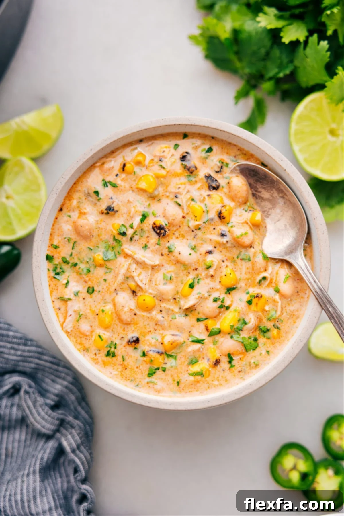 A beautifully garnished bowl of Crockpot White Chicken Chili, topped with cheese, sour cream, and cilantro, ready to be enjoyed.