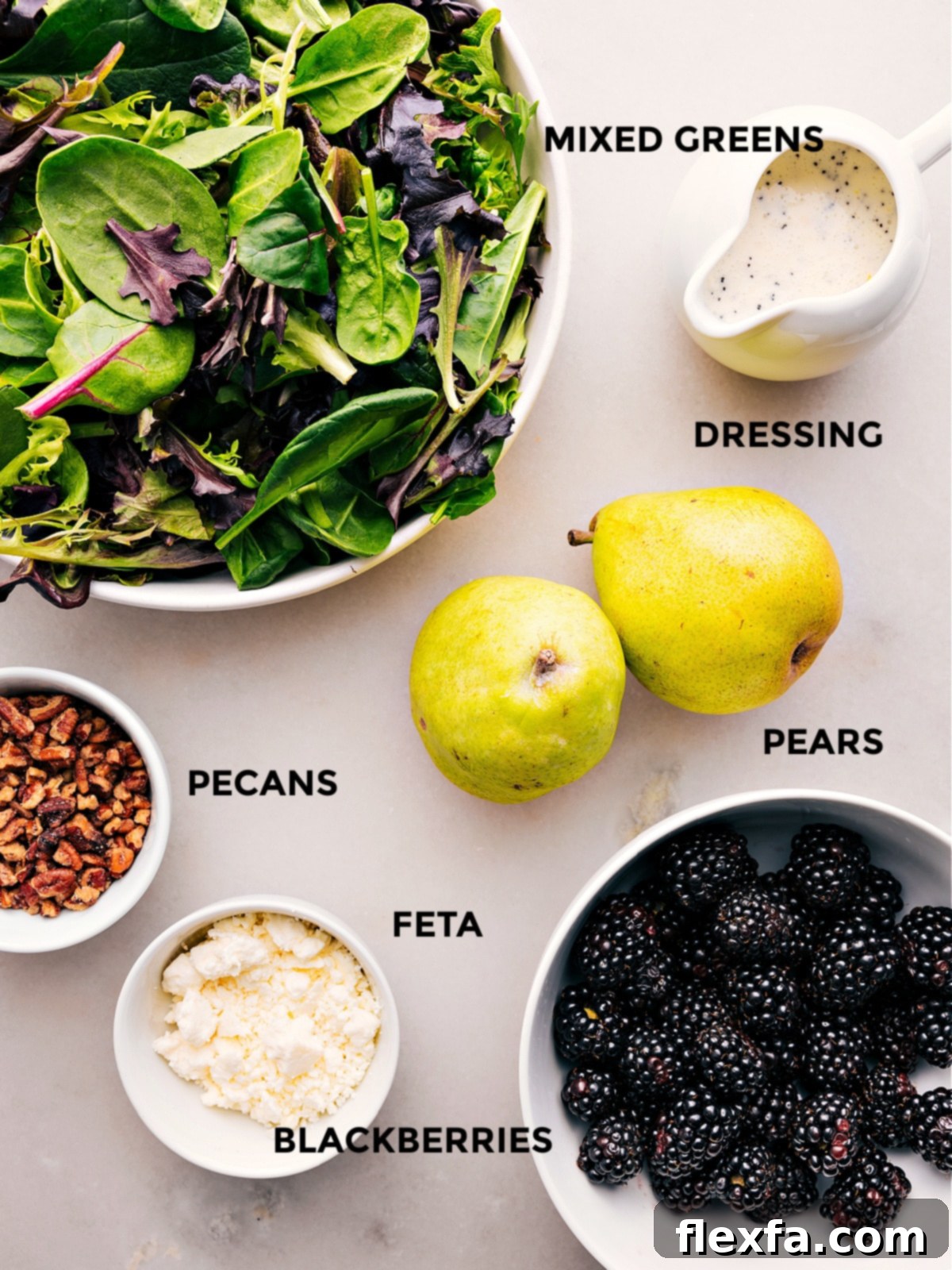 All the fresh ingredients for the Blackberry Salad laid out, including vibrant greens, plump blackberries, sliced pears, candied pecans, and feta cheese.