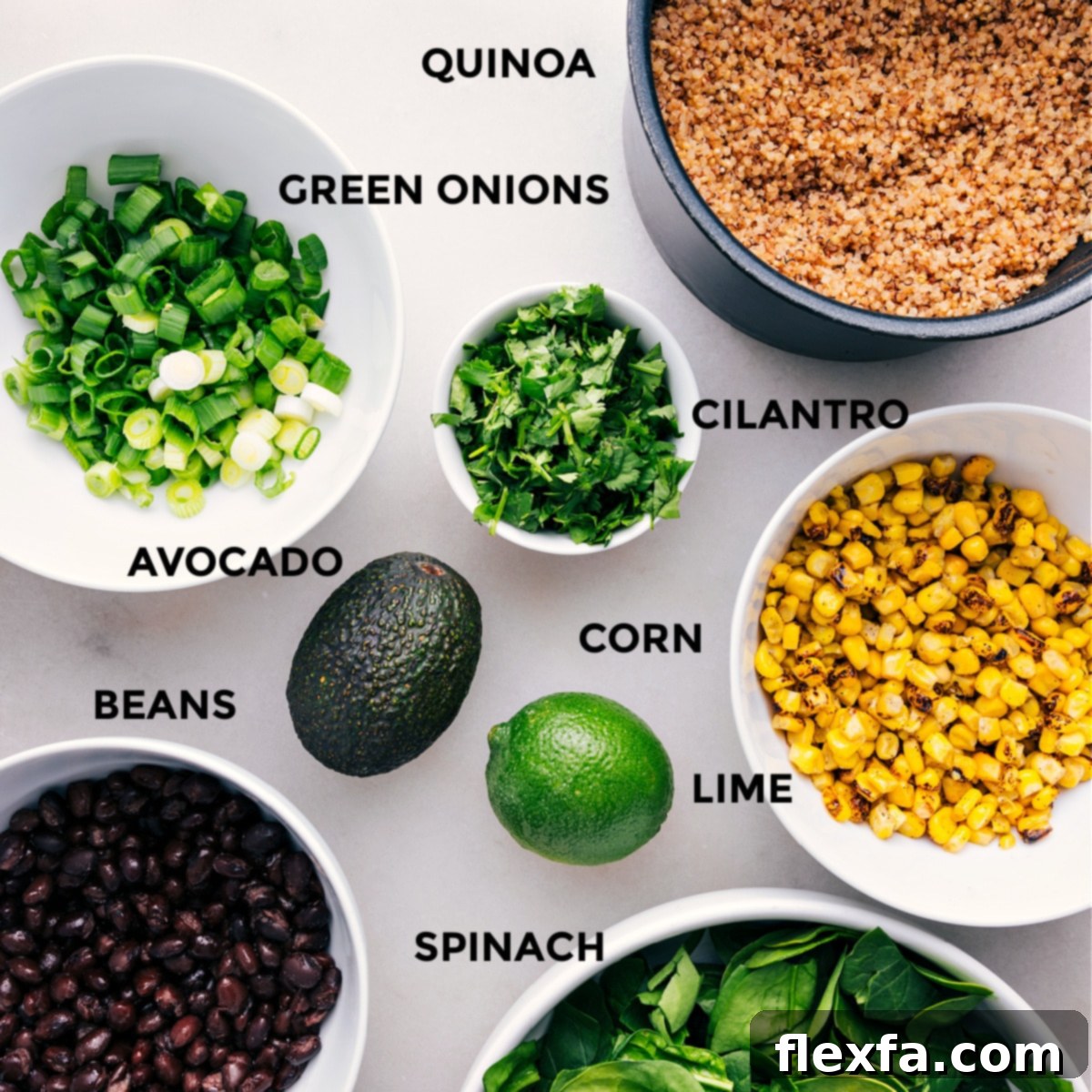 Fresh ingredients laid out for Quinoa Corn Salad: vibrant avocado, crisp corn kernels, dark black beans, fragrant cilantro, and finely chopped green onions.