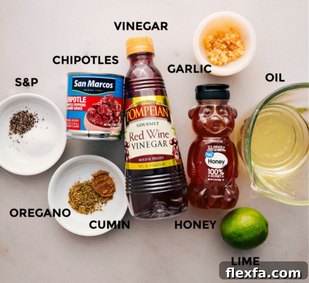 Ingredients prepared for the chipotle-lime vinaigrette: red wine vinegar, fresh lime, oil, garlic, chipotles in adobo, and various seasonings.