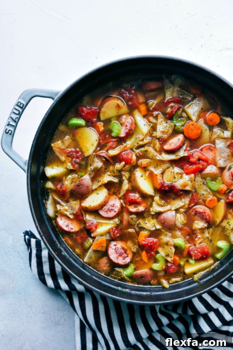 Hearty Sausage Cabbage and Potato Soup 4 A steaming bowl of hearty sausage, potato, and cabbage soup, garnished with fresh herbs, served with crusty bread on the side.