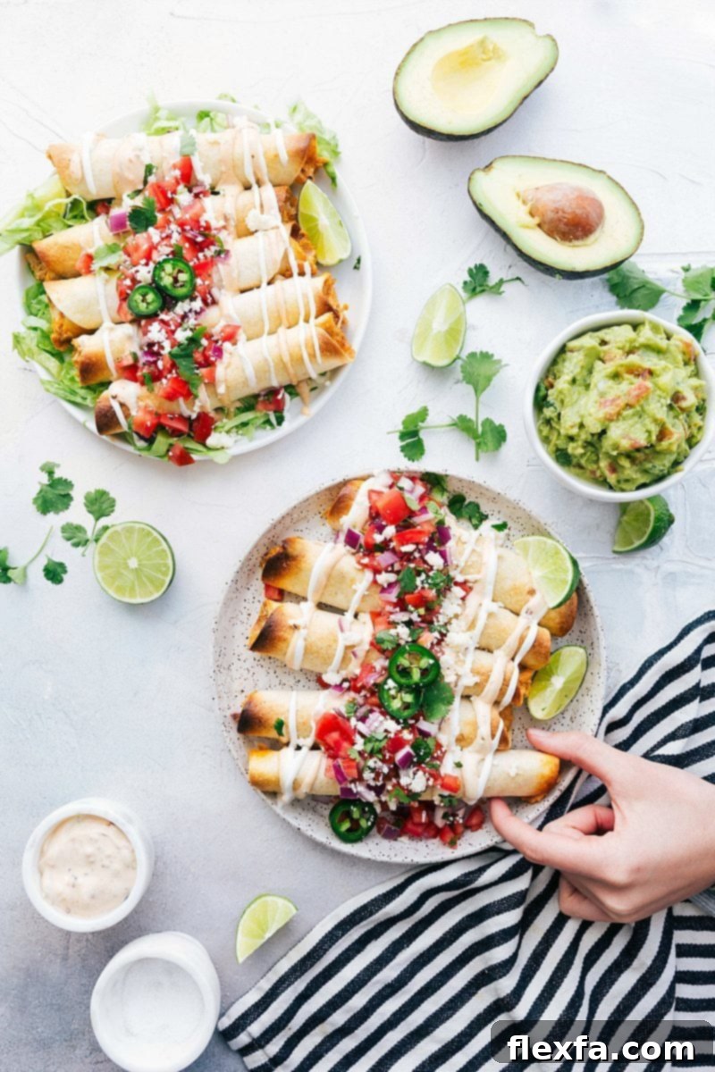 A vibrant close-up of baked chicken taquitos served on a rustic wooden board, garnished with fresh cilantro and lime wedges, surrounded by various dips and toppings.