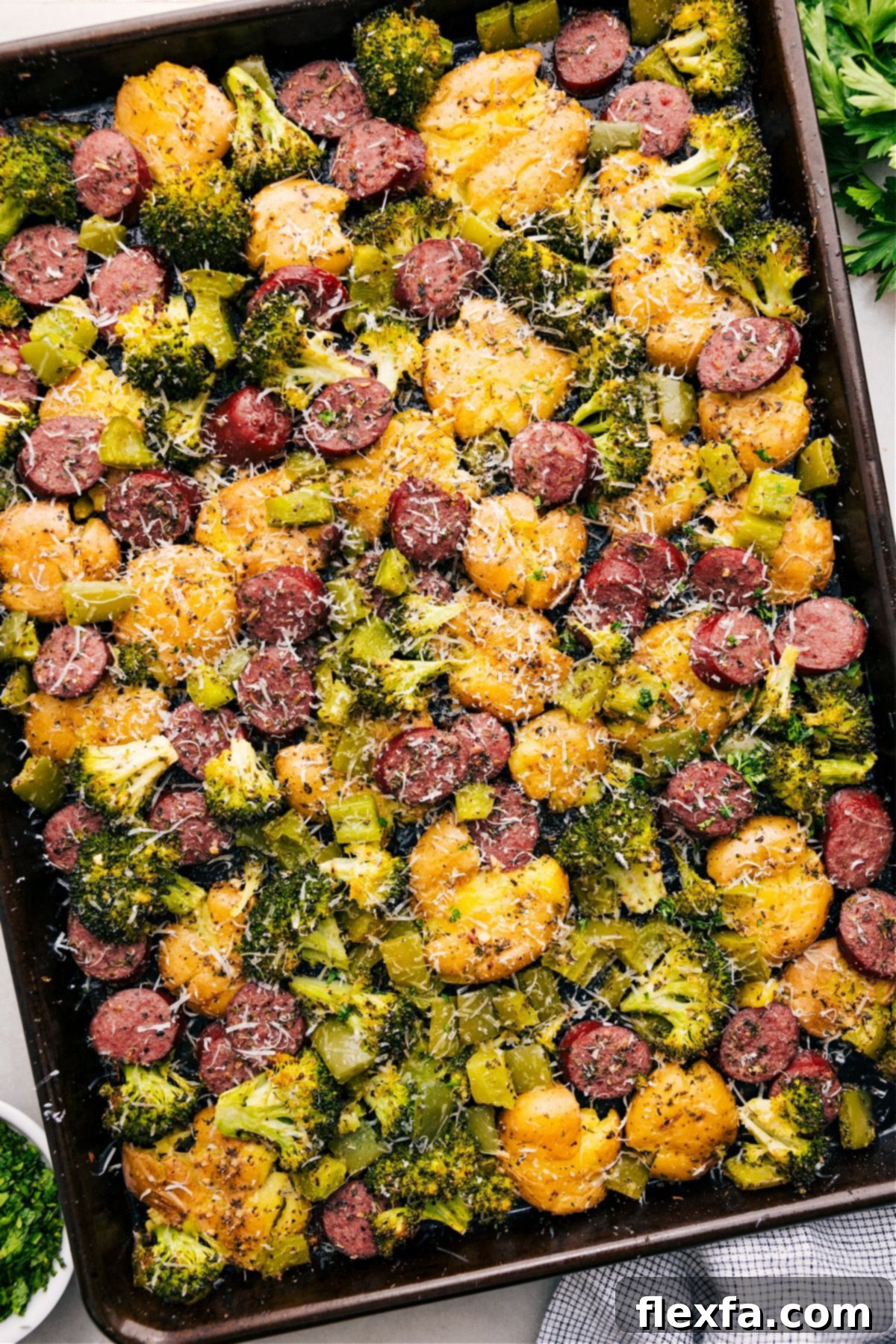A vibrant Sausage Potato Broccoli Sheet Pan dish with fresh Parmesan on top, ready to serve.