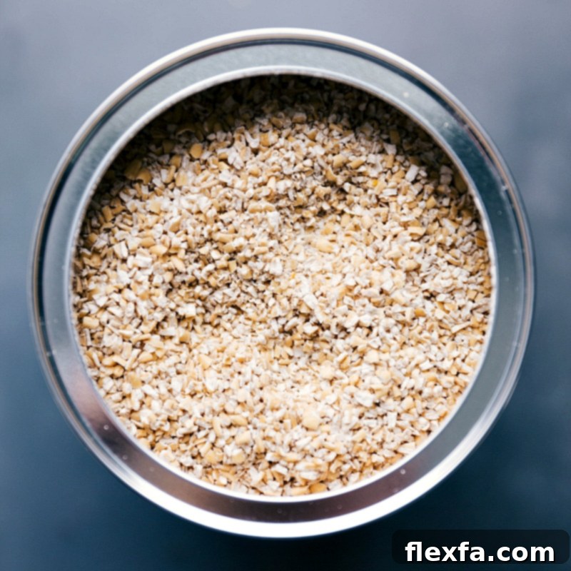 High-Quality Raw Steel-Cut Oats and Quinoa for a Hearty Breakfast Raw steel cut oats and white quinoa stored neatly in separate containers, ready for cooking.