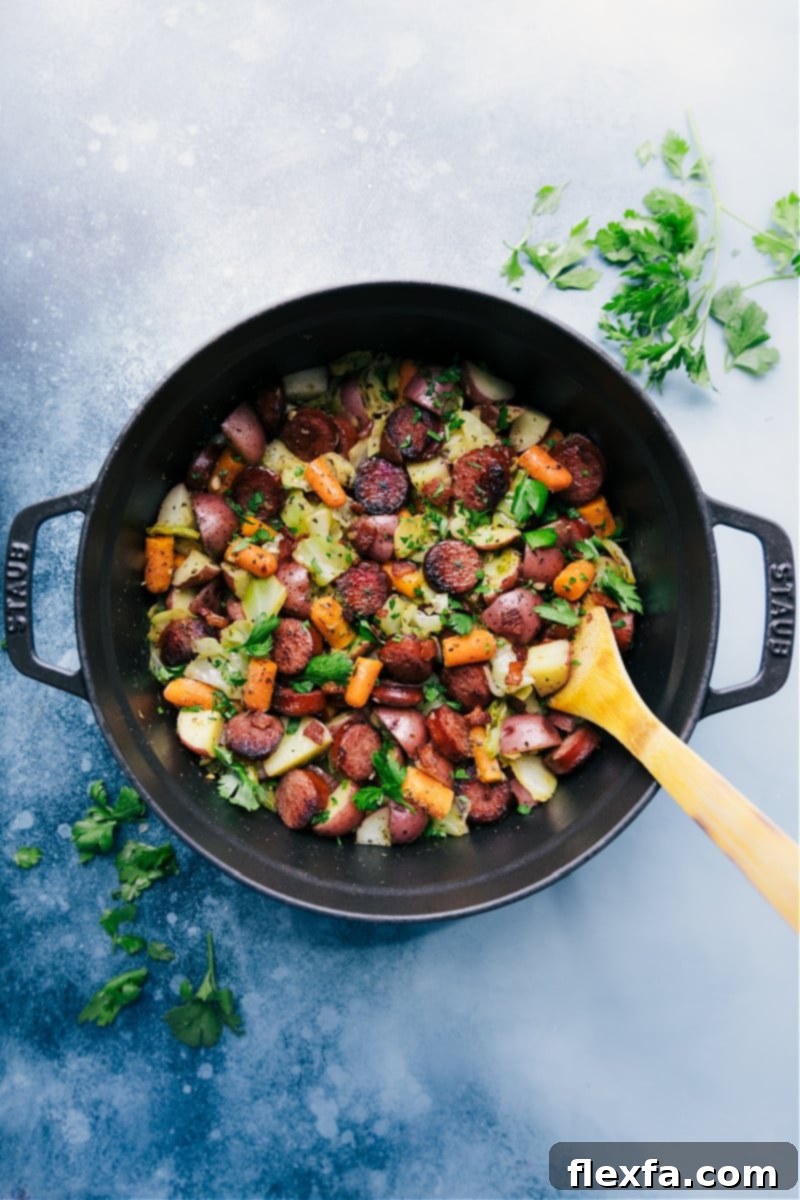 A large pot filled with cooked cabbage, potatoes, and sausage, ready to be served.