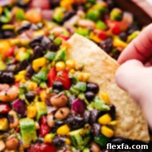 Cowboy Caviar in a bowl with a chip dipping in.