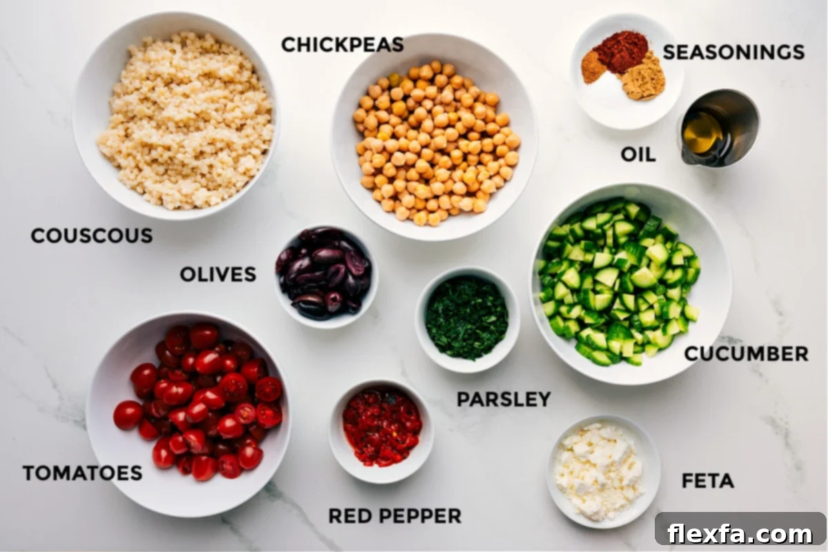 All the fresh and essential ingredients meticulously prepped and laid out for the easy assembly of the Mediterranean Chickpea Salad. This includes perfectly cooked chickpeas, pearled couscous, a selection of aromatic seasonings, rich olive oil, crisp diced cucumbers, fresh flat-leaf parsley, creamy crumbled feta cheese, colorful bell peppers, ripe cherry tomatoes, and briny Kalamata olives, all ready to be combined.