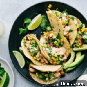 A close-up of a finished Mexican Street Corn Chicken Taco with sauce and toppings
