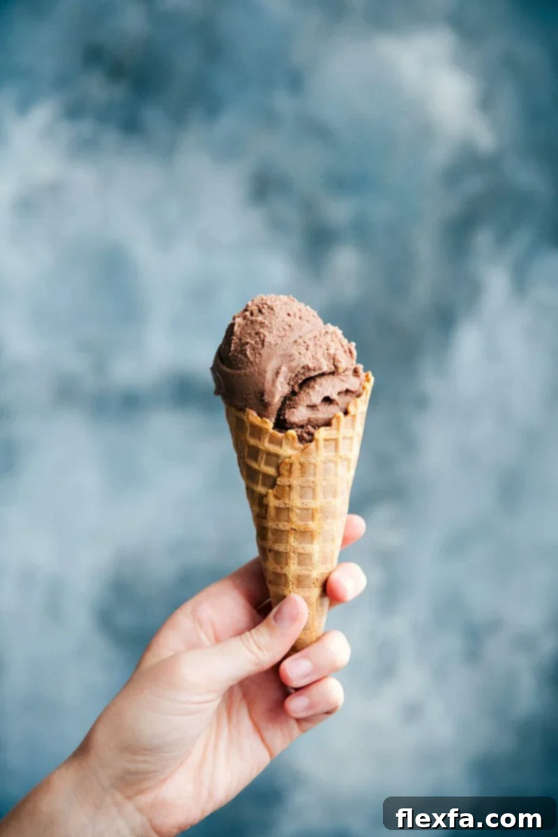 A waffle cone filled with rich and creamy homemade chocolate gelato, promising a delightful dessert experience.