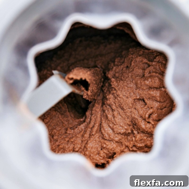 Chocolate gelato churning smoothly in an ice cream maker, illustrating the process of achieving a perfect creamy texture for homemade gelato.