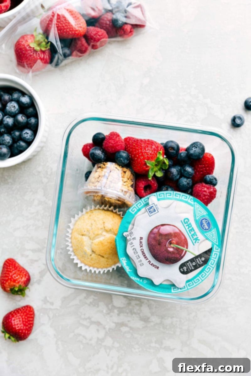 Yogurt parfait meal in a container, packed with yogurt, fresh fruit, and granola, ready to go.