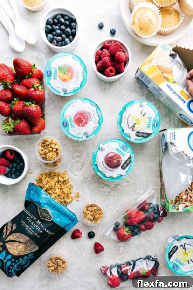 Several components of a fruit-and-yogurt school lunch, including fresh fruit and granola, all packed together for a nutritious meal.
