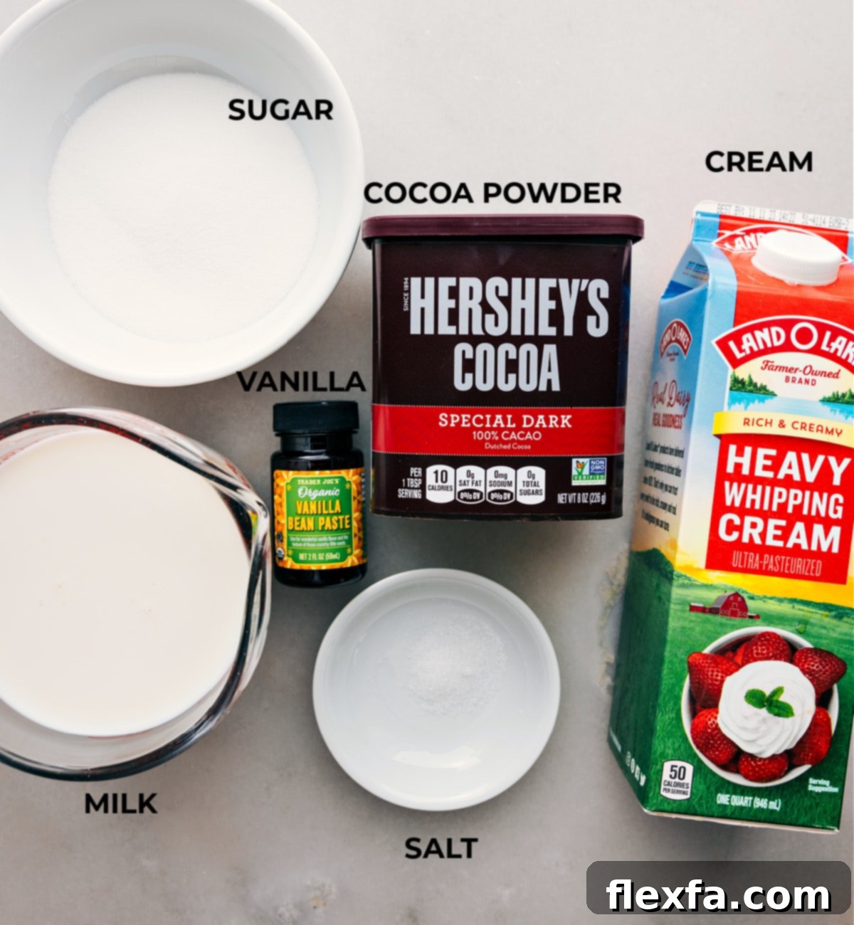 Carefully arranged ingredients for the perfect homemade hot chocolate, showcasing fresh cream, rich cocoa powder, granulated sugar, and other essential elements ready for preparation.