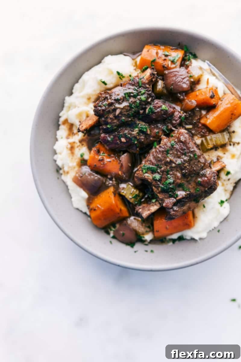Fall-Off-The-Bone Short Ribs 2 Perfectly cooked beef short ribs with a rich gravy and roasted vegetables, ready to serve.