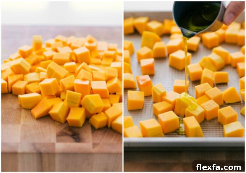 Butternut squash being chopped into cubes and coated in olive oil on a baking sheet.