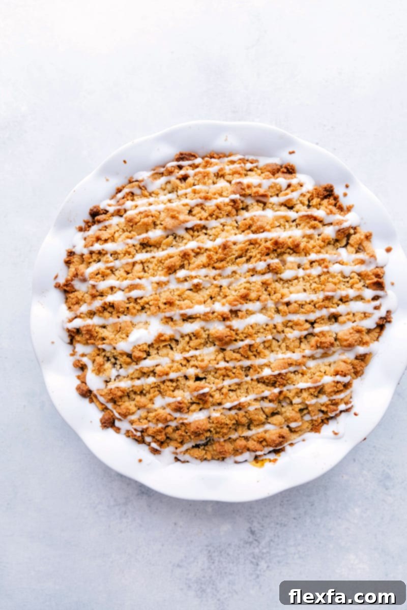 Overhead view of a freshly baked Cinnamon Roll Apple Pie, showcasing its golden brown crumble topping and the intricate cinnamon roll crust