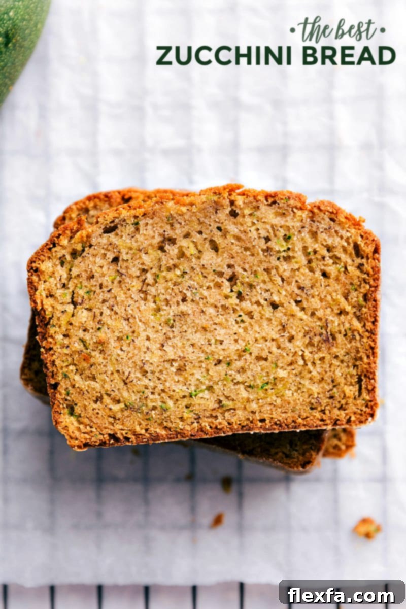 Stacked slices of moist Zucchini Bread ready to be enjoyed, showing its golden crust and flecks of green zucchini.