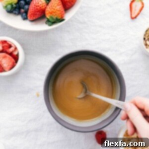 A close-up image of the finished vanilla sauce in a small serving bowl, garnished with a few fresh berries, highlighting its smooth and inviting texture.