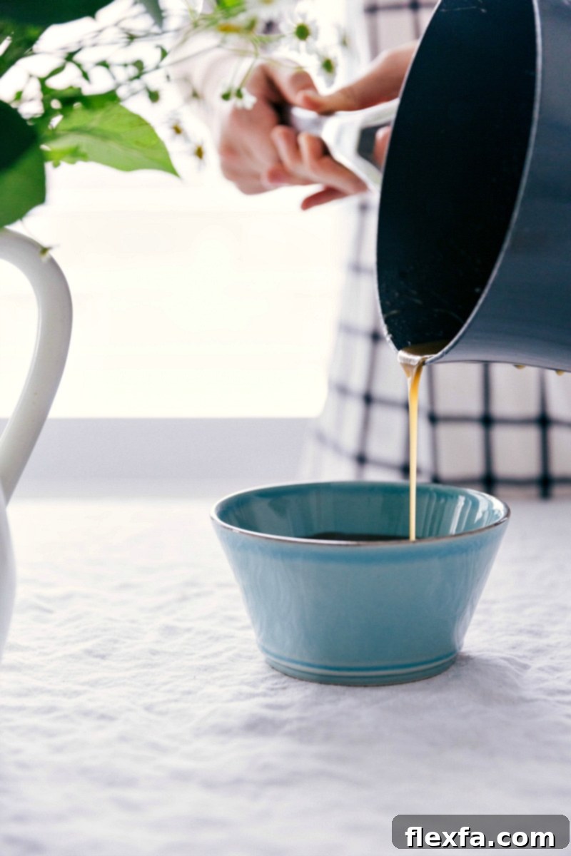 Image of the Homemade Vanilla Sauce being poured luxuriously into a elegant serving bowl, ready for use