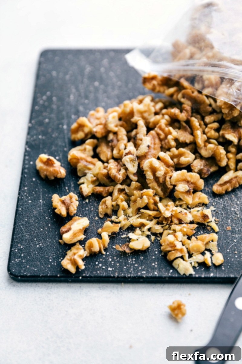 Close-up of walnuts being finely chopped on a wooden board, essential for adding a delightful crunch to the Banana Crepes.