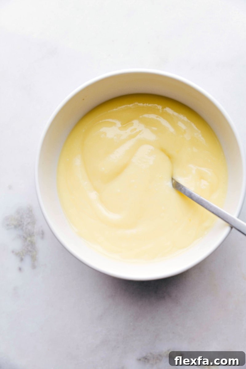 A bowl of rich, creamy homemade custard filling, ready to be spread onto delicate crepes.