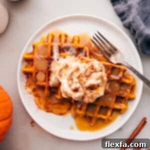 Close-up of fluffy pumpkin waffles with syrup and whipped cream