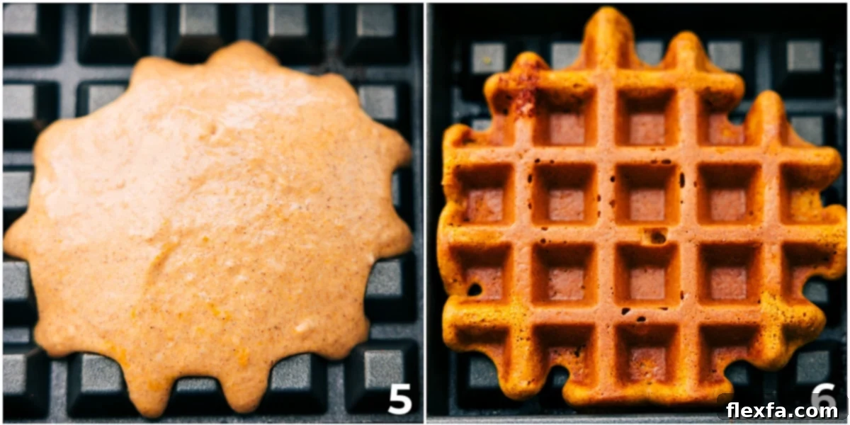 Freshly poured pumpkin waffle batter cooking in a hot waffle maker, showing the beginning of the crisping process.