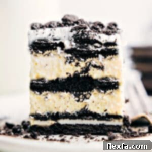 Close-up of a square slice of Oreo Icebox Cake, showing the distinct layers of cookie, pudding, and whipped cream.